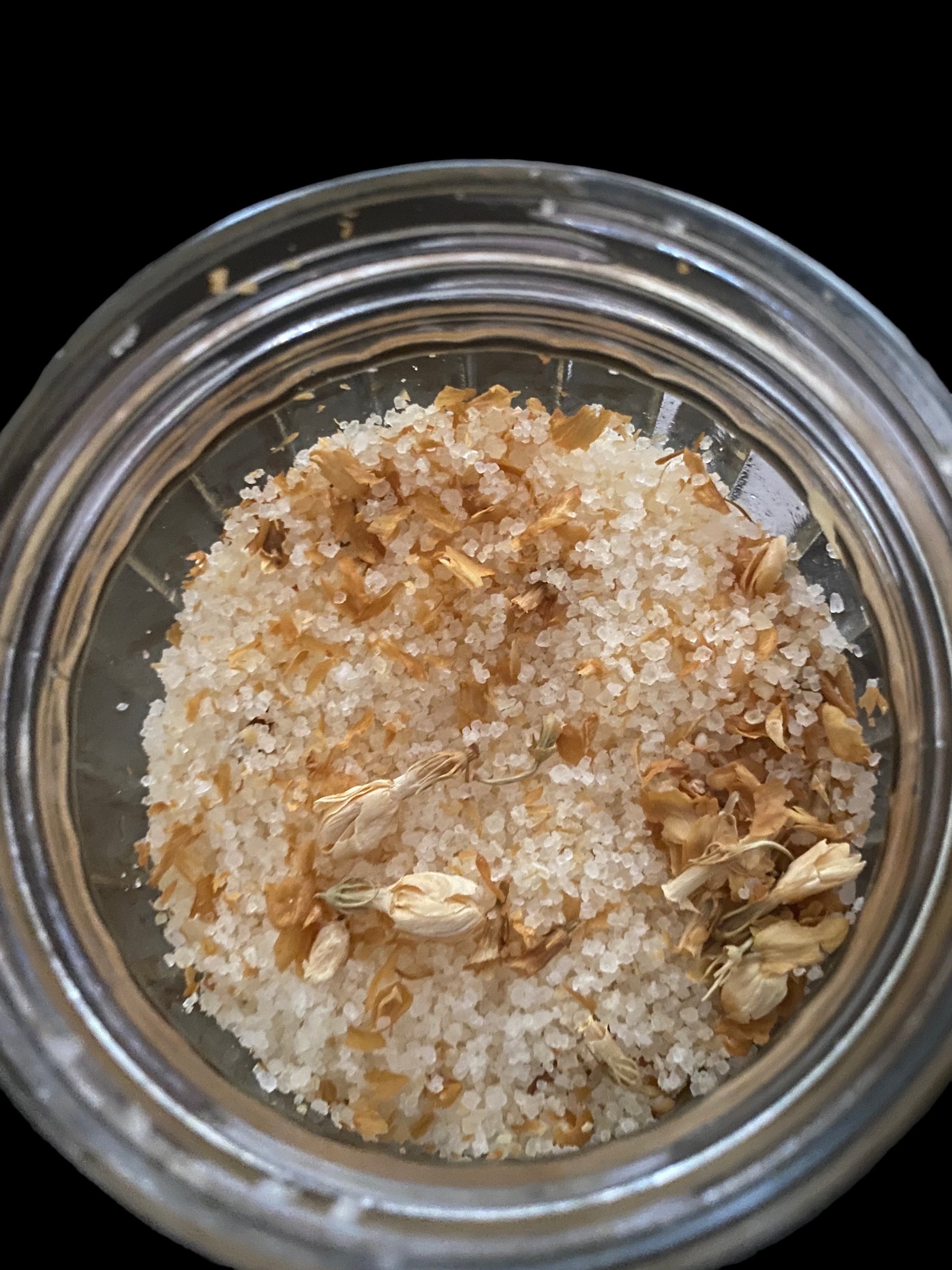 Clear Vintage Mason Jar Filled with Clove Lavender Chamomile Tea Tree and Geranium Essential Oils has Dead Sea Salt Pink Himalayan Sea Salt with Olive Jojoba Sunflower and Shae Butter Oils. Blends of Roses Jasmine and Albizzide Flowers.